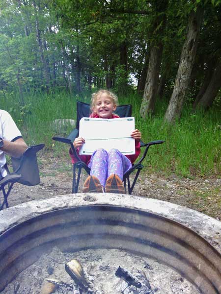 doing summer workbooks by the campfire