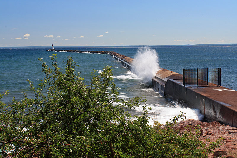 wave crashing into the pier at presque isle park